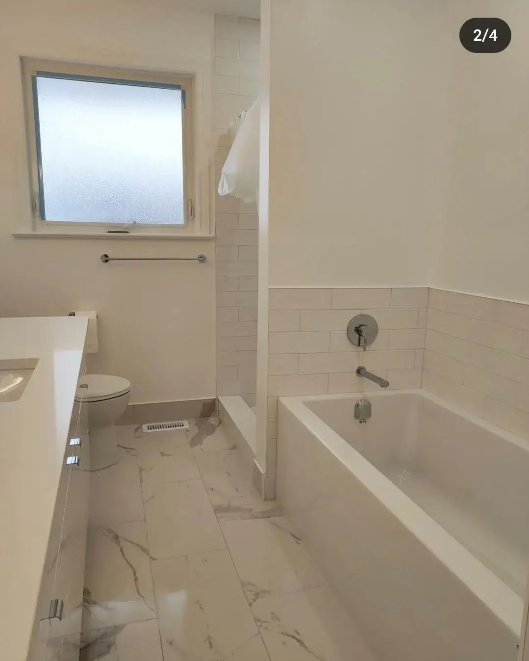 Bathroom with a new tiled tub surround and vanity