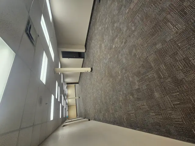 Carpet tile being installed in a commercial unit