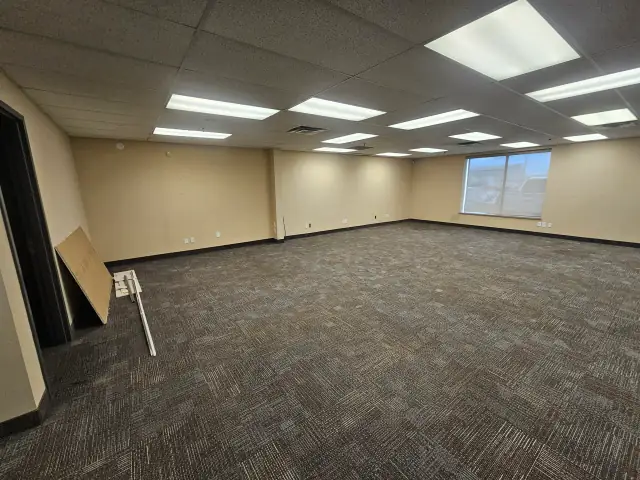 Renovated office space with new carpet tile and drop ceiling lighting